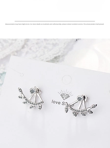 Close-up of leaf-shaped silver earrings with sparkling cubic zirconia on a white card