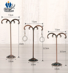 Detailed view of metal T-bar earring display stands with vintage bronze finish and ornate bases
