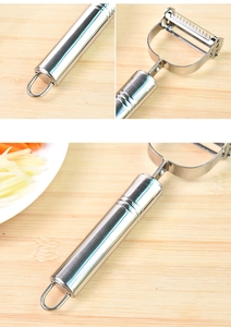 Close-up of stainless steel vegetable peeler handle with hanging loop on wooden board
