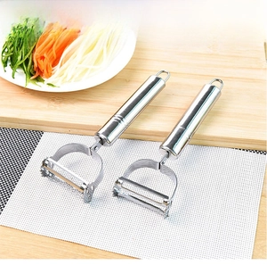 Dual-head stainless steel peeler and grater tool set on a wooden board for kitchen use