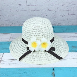 White woven sun hat with black ribbon bow and yellow plumeria flowers detail