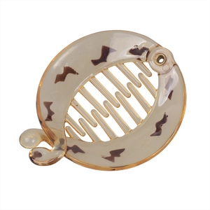 Detail view of tortoiseshell banana hair clip with interlocking teeth and leopard pattern