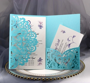 Macro shot of sky blue laser cut wedding invitation with floral inner cards and detail