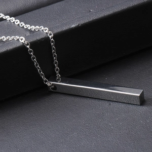 Macro view of silver bar necklace with crown engraving on premium black leather