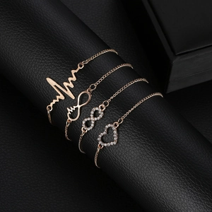 Four-piece gold bracelet set with heart, infinity, and heartbeat charms on black leather