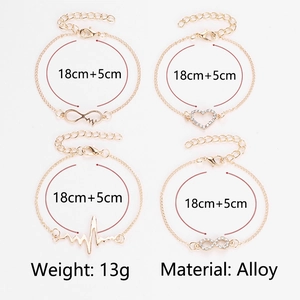 Detailed view of four-piece gold alloy bracelet set with heart and heartbeat motifs