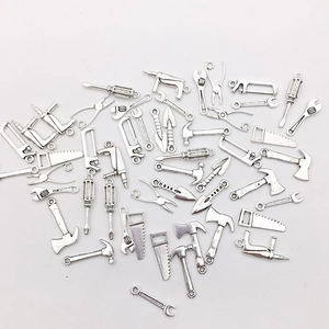 Assorted silver metal mini tool charms including hammer, wrench, and axe for DIY crafts