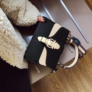 Chic black and beige patchwork crossbody bag with gold lock and striped webbing strap
