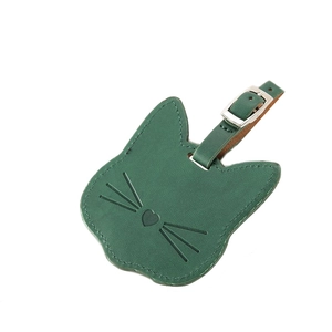 Green leather cat-shaped luggage tag with adjustable buckle strap on white background