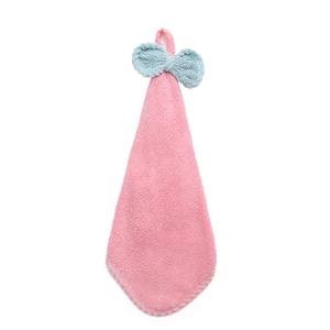 Soft pink coral fleece hand towel with a blue bow decoration and hanging loop on white backdrop