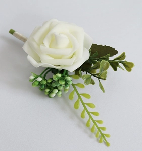Détail de la boutonnière de rose blanche en mousse PE avec feuilles vertes et baies
