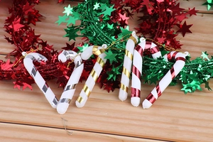 Close-up of 7cm festive plastic candy cane ornaments with star-shaped tinsel decorations