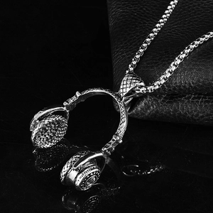 Polished stainless steel headphone pendant with box chain on a black reflective surface