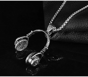 Detailed view of a silver headphone pendant on black leather with reflecting metal chain