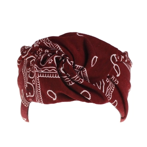 Detail of twisted headband in dark red with classic white paisley patterns on white backdrop