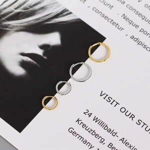 Detail view of twisted s925 silver hoop earrings in gold and silver finishes