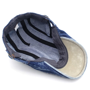 Internal view of a washed blue cotton denim cap showing the lining and 100% cotton label
