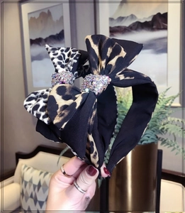 Detail of leopard print bow headband featuring shimmering rhinestone embellishments