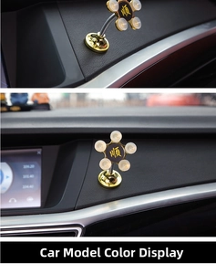 Detail of golden car phone holder with suction cup base and circular decorative character