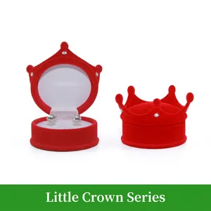 Red velvet crown-shaped jewelry box with soft white interior and sparkling stud earrings