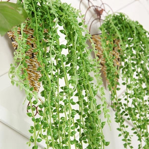 Close-up of artificial hanging succulents in decorative woven baskets on a wall grid