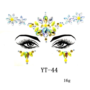 Macro shot of YT-44 iridescent and yellow acrylic face jewels for masquerade makeup