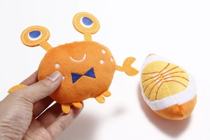 Detail shot of orange plush crab and orange slice pet toy with soft fabric texture