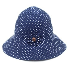 Detail of blue sun hat with white polka dots featuring a fabric flower and button accent