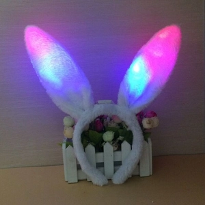 Close-up of white plush LED bunny ears headband with pink and blue glowing lights