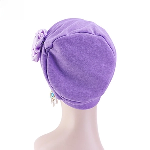 Détail du turban violet montrant la maille élastique et la fleur avec pendentif en pierre