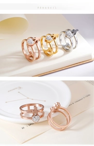 Detail view of double-layer heart rings with a child silhouette in gold and silver finishes