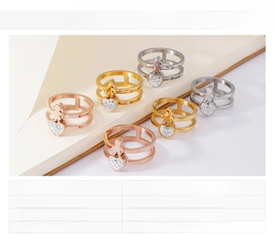 Detail view of 18K gold plated stainless steel double layer rings with heart and figure charms