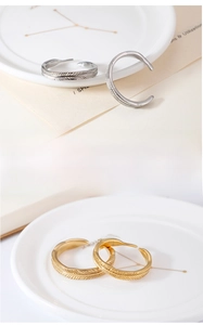 Detail view of adjustable feather rings with intricate textures in gold and silver finish