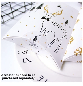 Close-up of reindeer pattern Christmas pillow gift boxes on white porcelain plate
