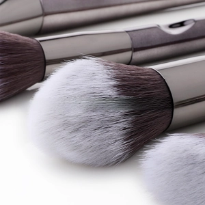 Macro shot of two-tone fiber bristles and polished metal handle on a makeup brush