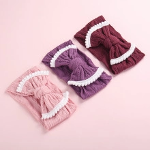Detailed macro shot of corduroy baby headbands with lace edges in pink and purple