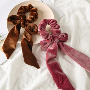 Detail of velvet bow scrunchies in brown and pink on a decorative display tray