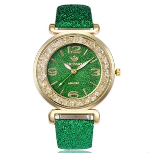 Detailed shot of gold watch case with sparkling rhinestones and green glitter dial