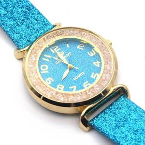 Detailed macro view of gold watch case with blue sparkling strap and crystal bezel