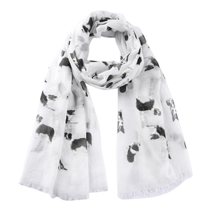 Detail of lightweight white scarf featuring black border collie prints and tassel edges