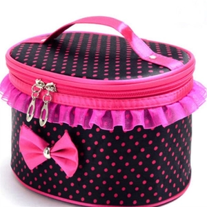 Beauty case rosa a pois con pizzo e manico a fiocco su sfondo bianco puro