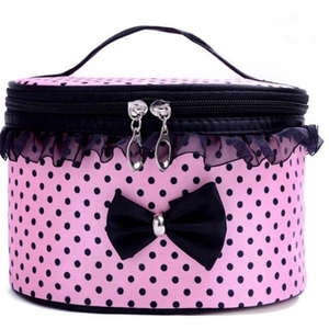 Pink polka dot cylindrical makeup bag with black lace trim and bow accent