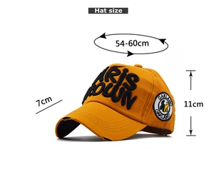 Close-up of Paris Crown embroidery and Oakland badge on yellow cotton baseball cap