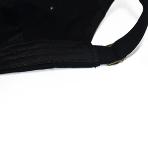 Detail of adjustable metal buckle and black cotton fabric on the baseball cap back