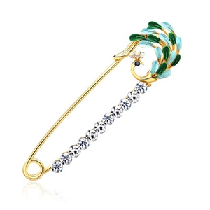 Macro shot of peacock brooch with gold metal and green-blue enamel and crystals
