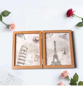 Detail of a double folding light wood picture frame with vintage architecture prints