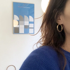 Close-up of minimalist gold hoop earrings shown on a model for actual size and fit