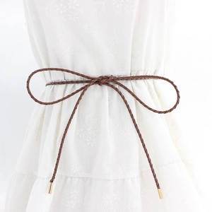 Women's brown woven PU leather waist chain belt with gold tips on a white floral dress