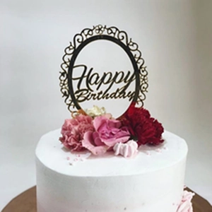Close-up of a double-layer acrylic Happy Birthday cake topper on a floral cream dessert