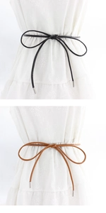 Detail of slim leather waist cords in black and brown with silver metal ends for dresses